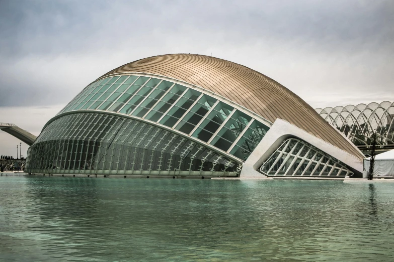 a large building next to a body of water, inspired by Zaha Hadid, unsplash contest winner, art nouveau, santiago calatrava, aquarium, spanish, large shell