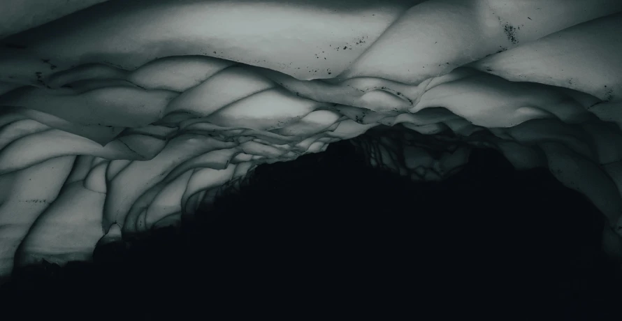 a black and white photo of the inside of a cave, inspired by Anna Füssli, pexels contest winner, conceptual art, beautiful fractal ice background, somber colors, ceiling hides in the dark, black watercolour