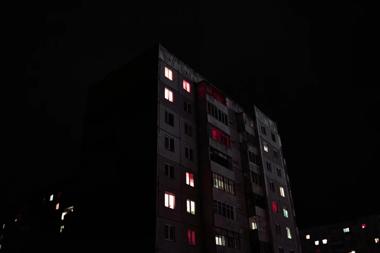 a tall building with windows lit up at night, inspired by Elsa Bleda, bauhaus, black and red colors, norilsk, digital photo, pink