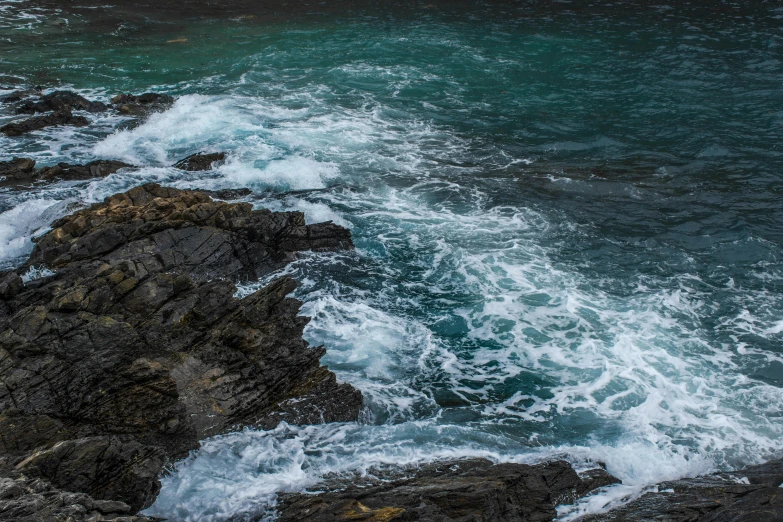 a man standing on top of a rock next to the ocean, pexels contest winner, process art, whirlpool, orkney islands, close-up photo, turquoise ocean