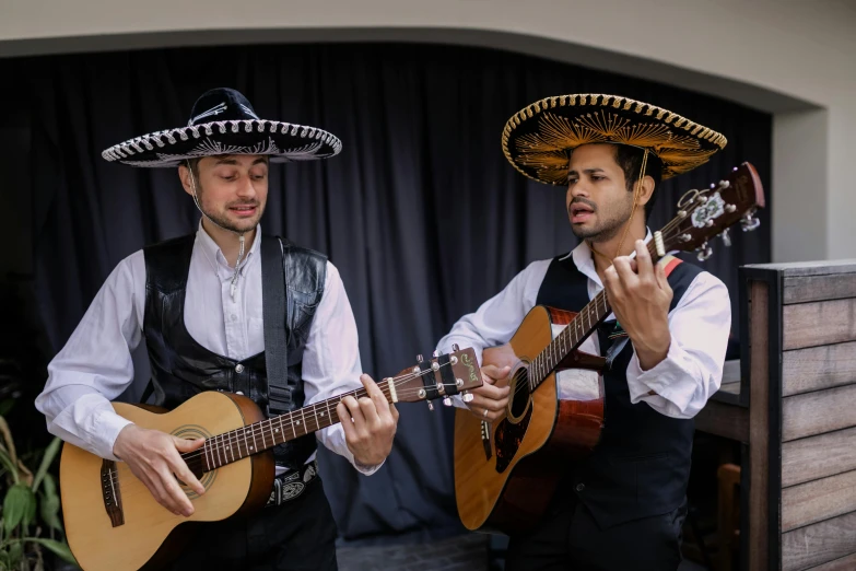 a couple of men standing next to each other holding guitars, inspired by Germán Londoño, sombrero, singing, performing, avatar image