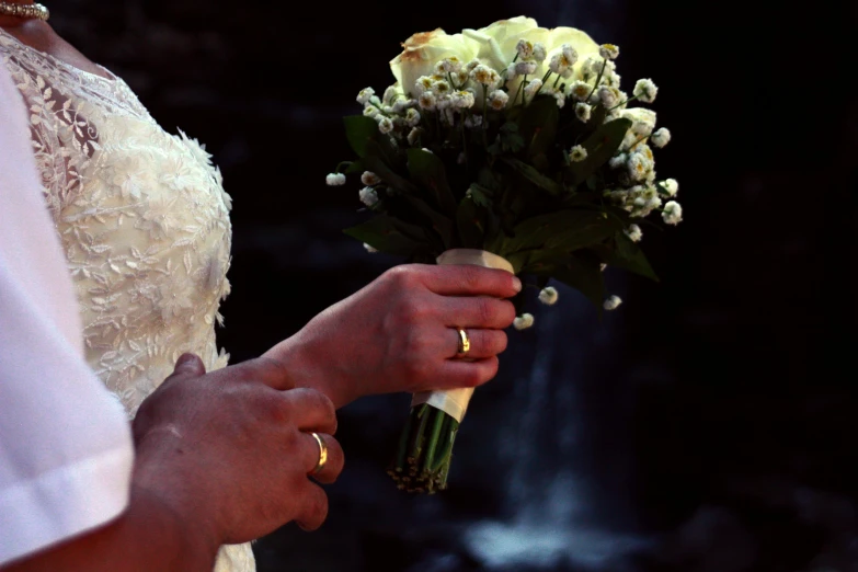 a close up of a person holding a bouquet, by Alison Watt, romanticism, water falls, wedding photography, enhanced, rings