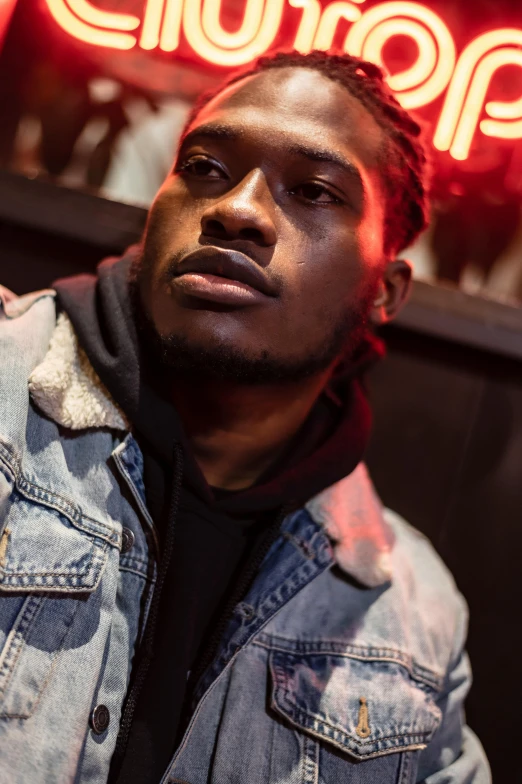 a man standing in front of a neon sign, an album cover, by Amos Ferguson, trending on pexels, playboi carti portrait, looking to his side, sittin, rugged