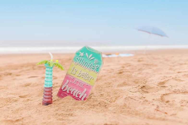 a sign sitting on top of a sandy beach, by Rachel Reckitt, pexels contest winner, tall iced tea glass, summer lighting, gradient and patterns wallpaper, beautiful magical palm beach