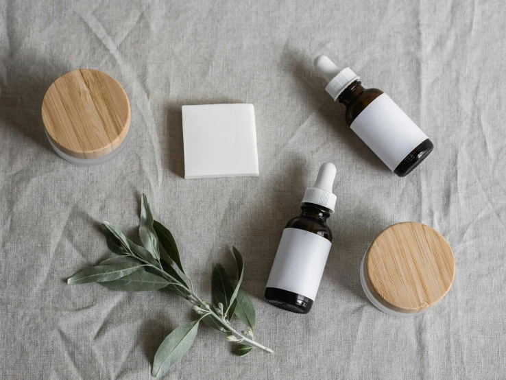 a couple of bottles sitting on top of a table, inspired by Eden Box, trending on pexels, skincare, white clay, medical labels, on wood