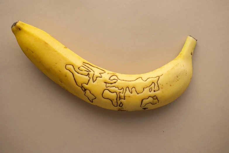 a close up of a banana on a table, by Ellen Gallagher, graffiti, based on geographical map, hand carved, 2019 trending photo, credit nasa