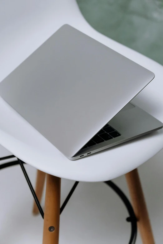 a laptop sitting on top of a white chair, by Carey Morris, rounded shapes, close up image, table, headshot
