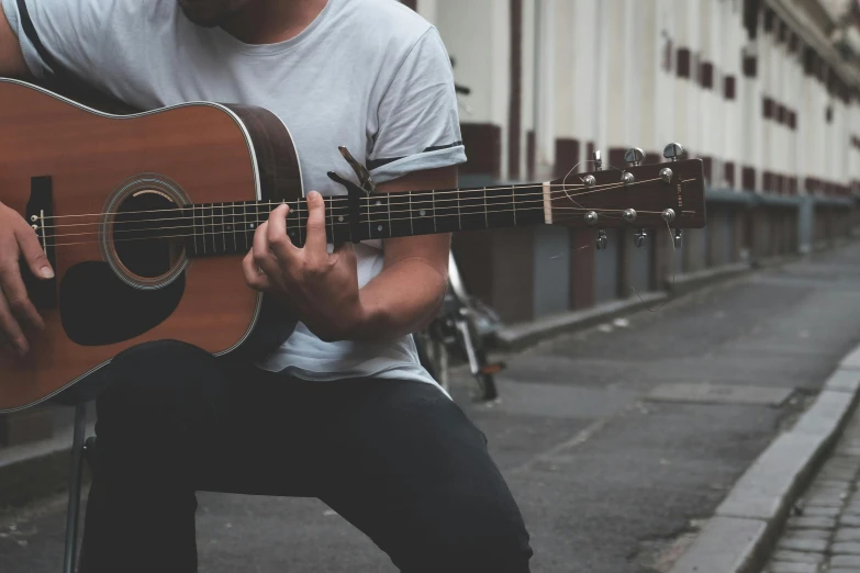 a man sitting on a chair playing a guitar, pexels contest winner, realism, standing in the streets, avatar image, background image, close up portrait photo