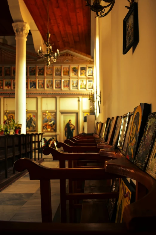 a room that has a bunch of paintings on the wall, by Demetrios Farmakopoulos, flickr, renaissance, in this church interior, benches, wooden banks, late afternoon