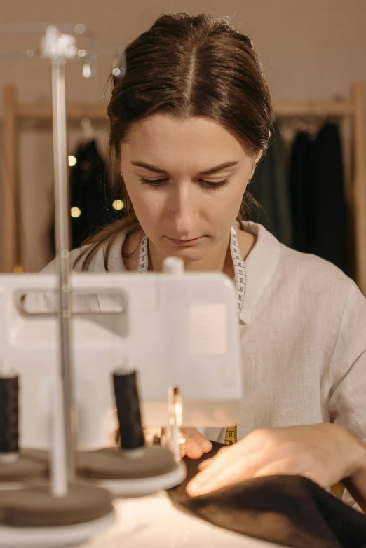 a woman is working on a sewing machine, by Emma Andijewska, trending on pexels, renaissance, stop motion animation, wearing light, low quality photo, portrait photo