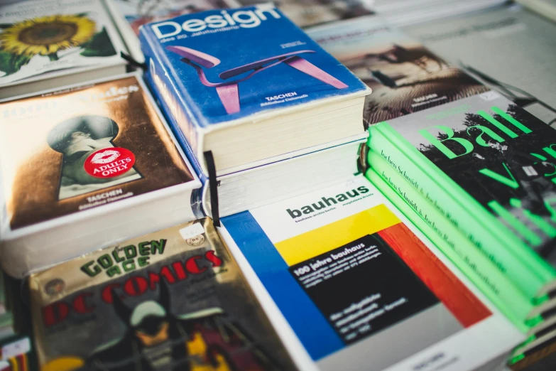 a pile of books sitting on top of a table, unsplash, bauhaus, 9 9 designs, read a directory book, coloured photo, part leyendecker style