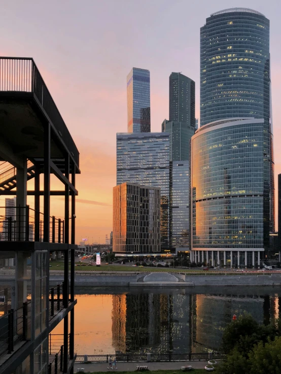 a large body of water surrounded by tall buildings, an album cover, inspired by Konstantin Vasilyev, pexels contest winner, socialist realism, late summer evening, russian architecture, russia in 2 0 2 1, seen from outside