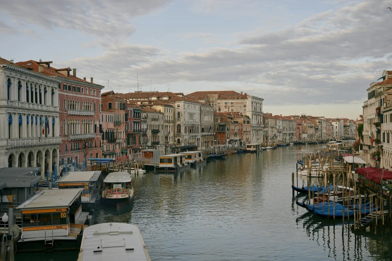 a canal filled with lots of boats next to tall buildings, a photo, renaissance, venice biennale's golden lion, 2022 photograph, early morning light, “diamonds