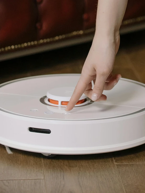 a person using a robotic vacuum cleaner on the floor, reddit, process art, tiktok video, sleek white, cinematic shot ar 9:16 -n 6 -g, detailed product image
