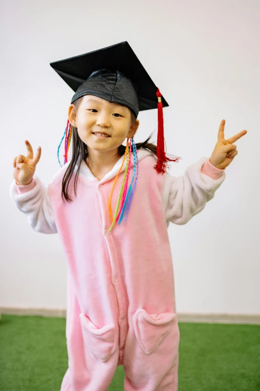 a little girl wearing a graduation cap and gown, inspired by Li Di, standing in class, eeri, with index finger, taken in 2022