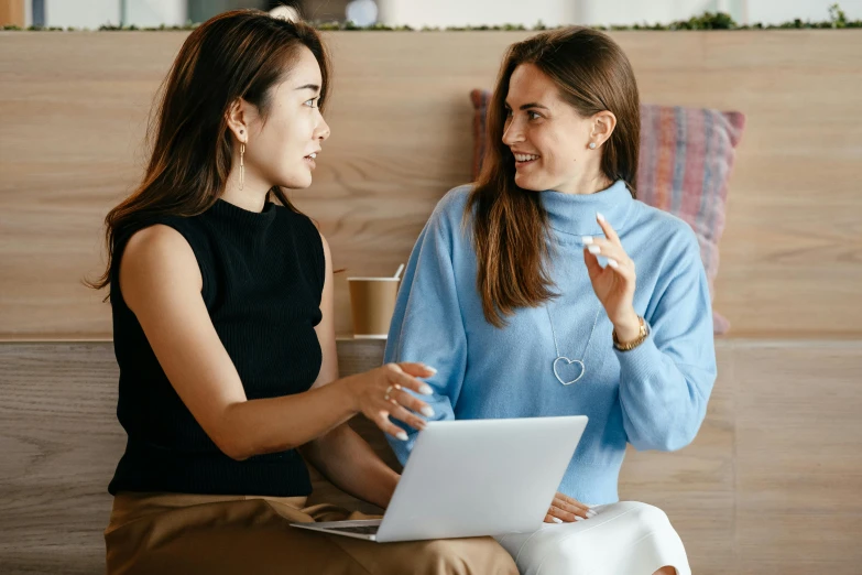 two women sitting on a bench talking to each other, trending on pexels, happening, in front of a computer, avatar image, attractive photo, looking her shoulder