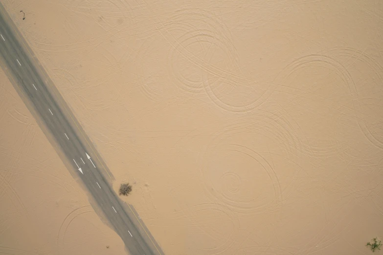 an aerial view of a street next to a wall, an album cover, inspired by Lucio Fontana, trending on reddit, lyrical abstraction, during sandstorm, flying beetles, simple ceiling, microscopic detail