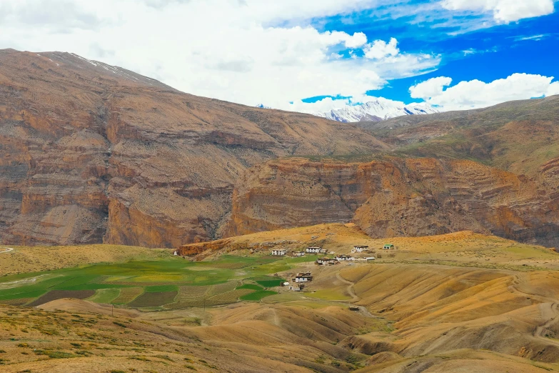 a view of a valley with mountains in the background, by Muggur, pexels contest winner, hurufiyya, with village, earthy colours, khedival opera house, high altitude