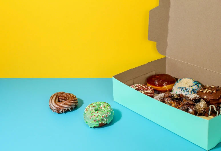 a box of donuts sitting on top of a blue table, various styles, detailed product image, no cutoff, product shot