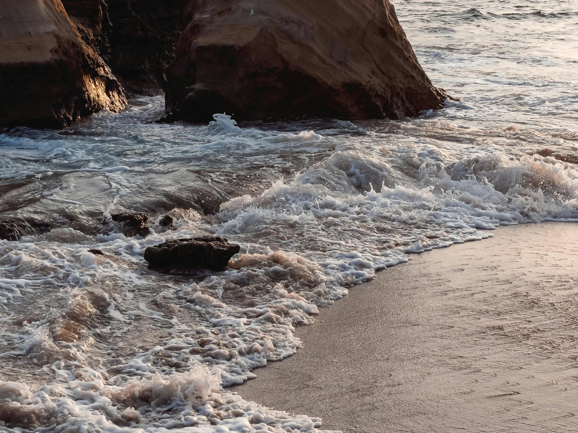 a man riding a surfboard on top of a sandy beach, by Carey Morris, pexels contest winner, renaissance, waves crashing at rocks, brown water, thumbnail, hollister ranch