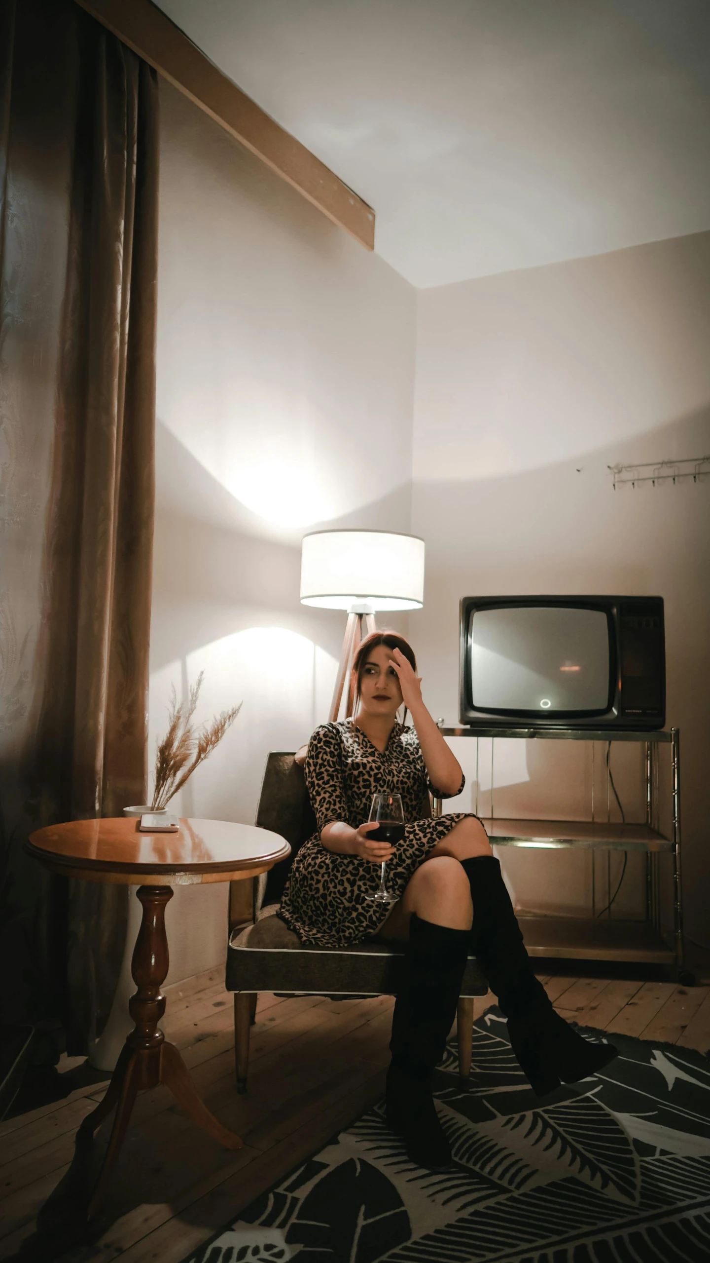 a woman sitting in a chair in a room, inspired by Elsa Bleda, pexels contest winner, realism, it is visibly angry at the tv, hotel room, instagram story, emerging from a lamp