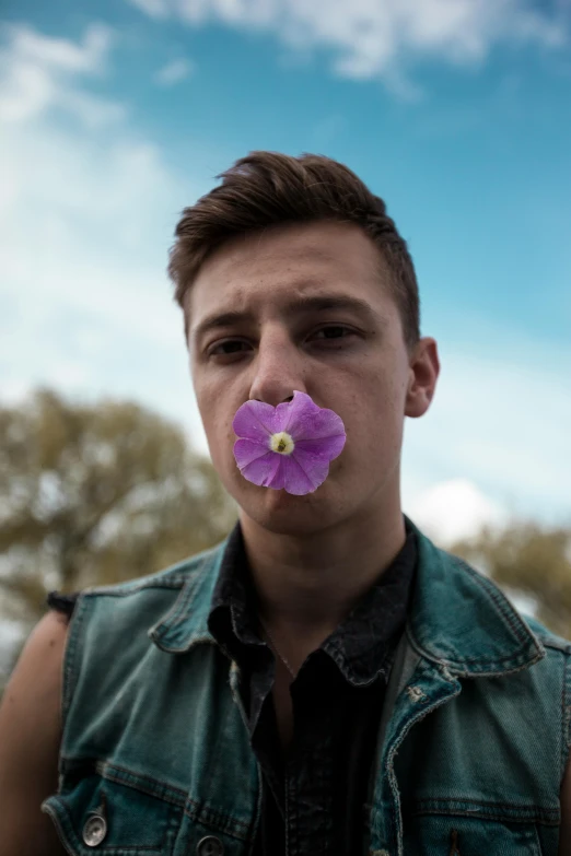 a man with a flower in his mouth, an album cover, trending on unsplash, twink, violet flower, caspar david, tourist photo