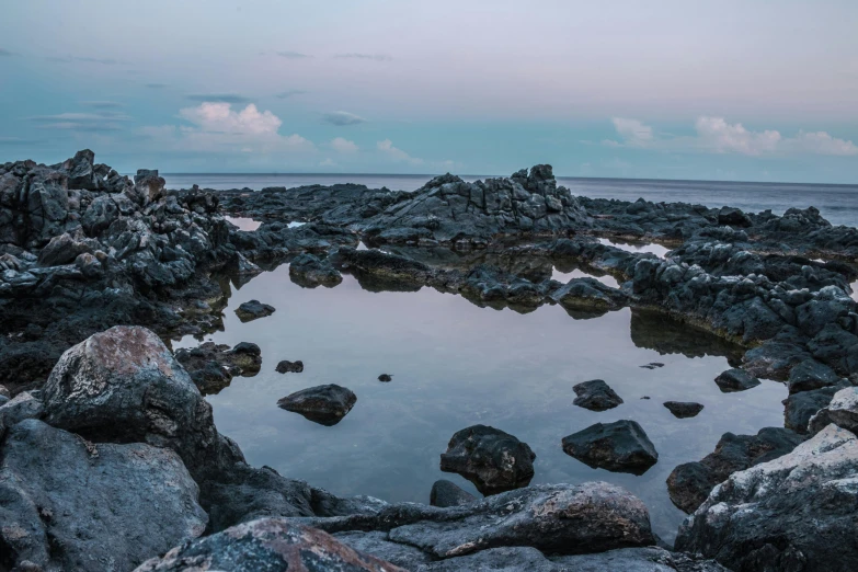 a body of water sitting on top of a rocky beach, a picture, rock pools, in the evening, reunion island, unsplash 4k