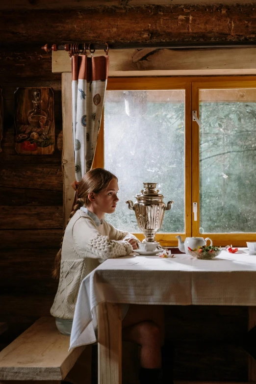 a couple of people that are sitting at a table, inspired by Valentin Aleksandrovich Serov, pexels contest winner, fine art, wide shot of a cabin interior, ukrainian girl, tea, children's