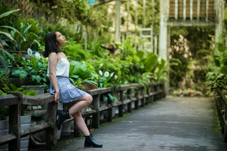 a woman sitting on top of a wooden bench, plaid skirt, botanic garden, avatar image, green alleys