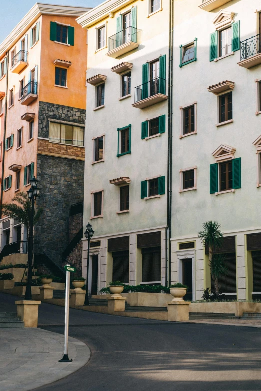 a man riding a skateboard down a street next to tall buildings, inspired by Ricardo Bofill, unsplash, renaissance, mediterranean fisher village, monaco, square, exterior photo