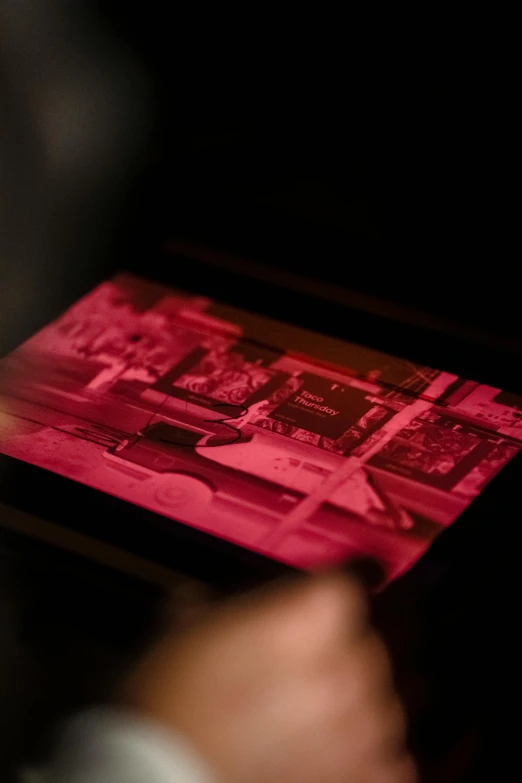 a close up of a person holding a tablet, a hologram, by Glennray Tutor, trending on unsplash, video art, blueprint red ink, masterpiece tintype, pink light, inking etching screen print