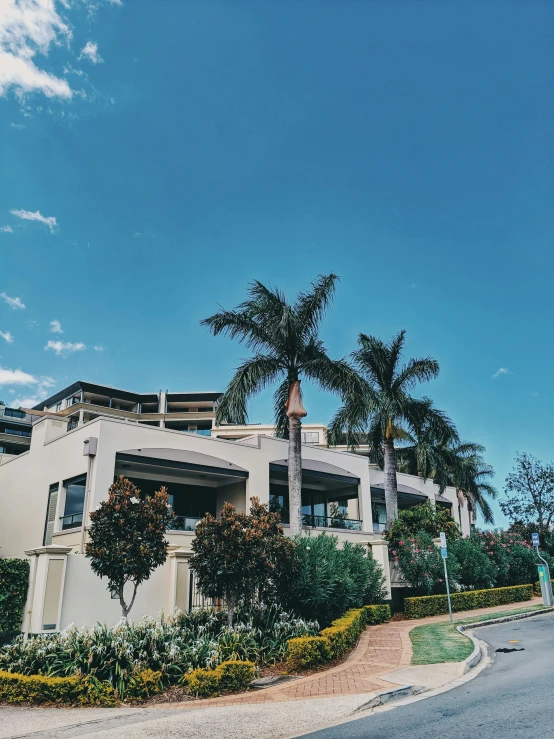 a large white building sitting on the side of a road, gold coast australia, 8k 28mm cinematic photo, beautiful magical palm beach, snapchat photo