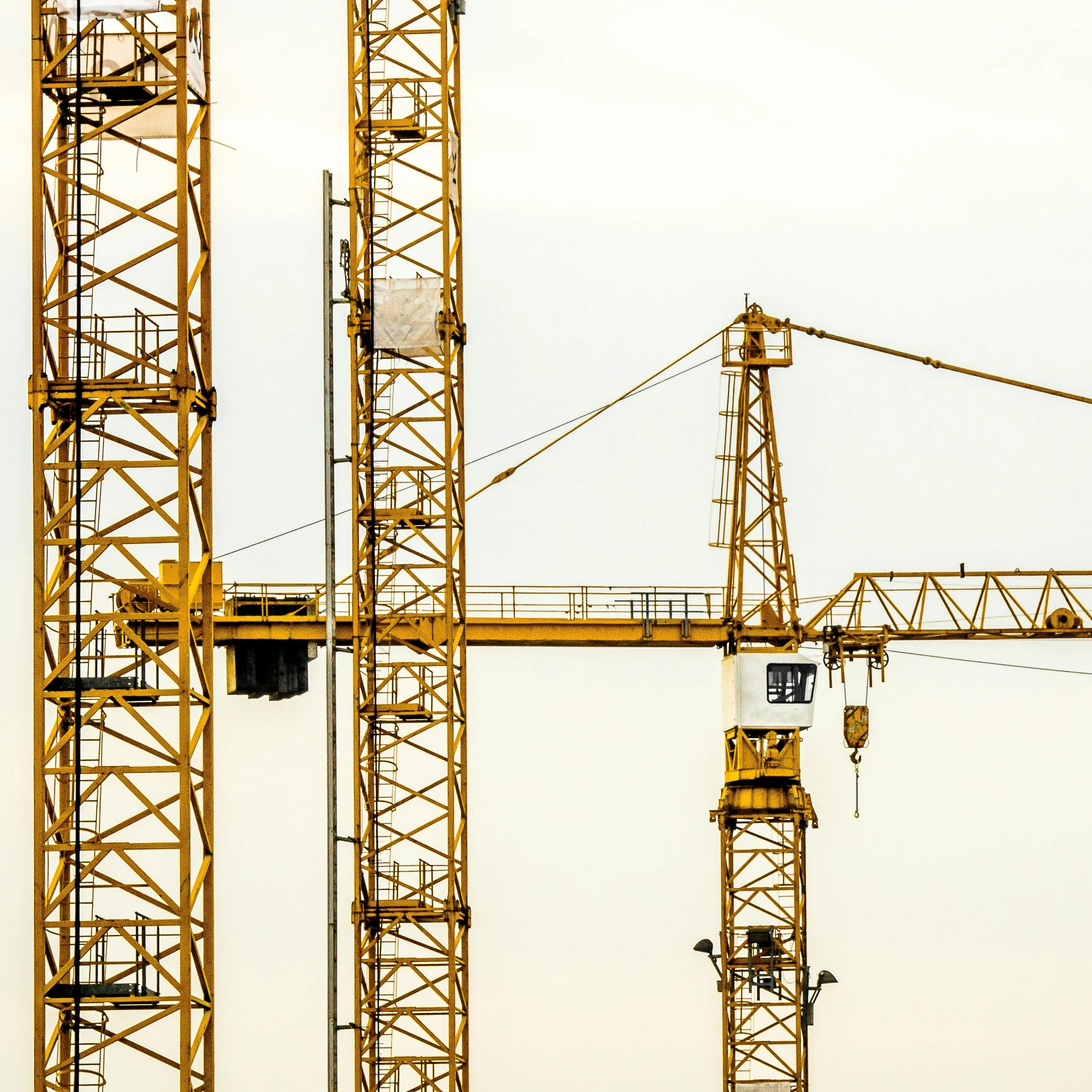 a group of cranes sitting next to each other, by Adam Marczyński, unsplash, constructivism, three towers, gold, low detail, instagram post