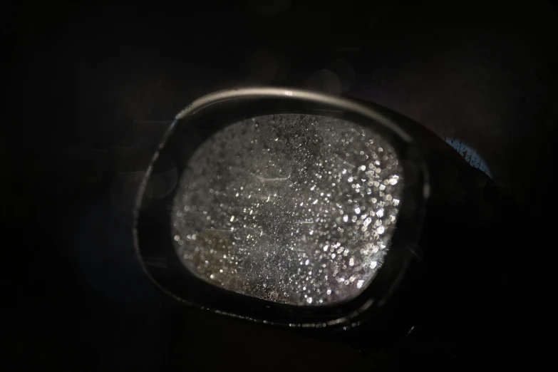 a close up of the side view mirror of a car, a microscopic photo, by Adam Marczyński, sparkling dark jewelry, sugar sprinkled, moonlight showing injuries, grey and silver