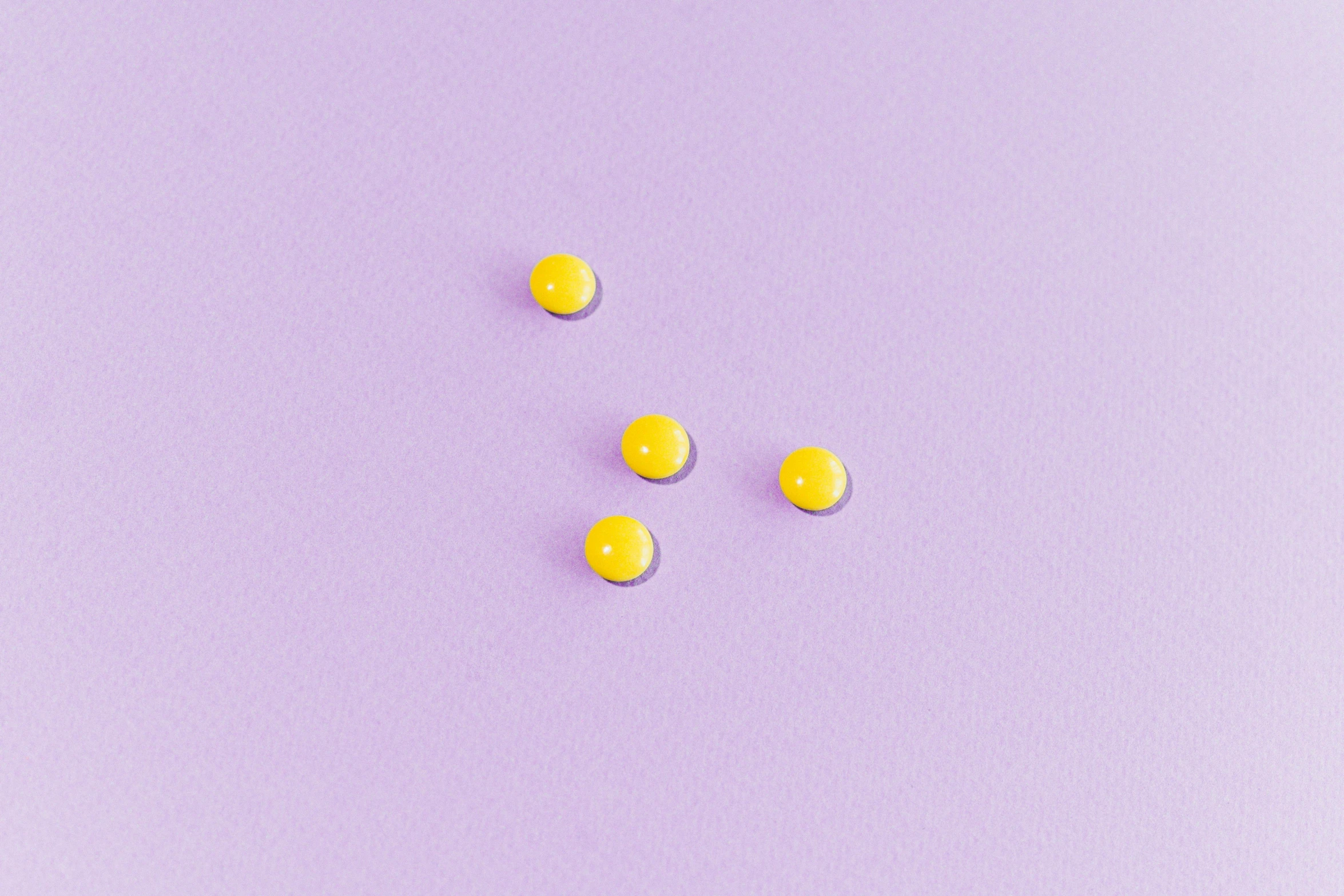 yellow pills on a purple background, inspired by Yahoo Kusama, trending on pexels, five planets, enamel, lemonade, minimalistic aesthetics