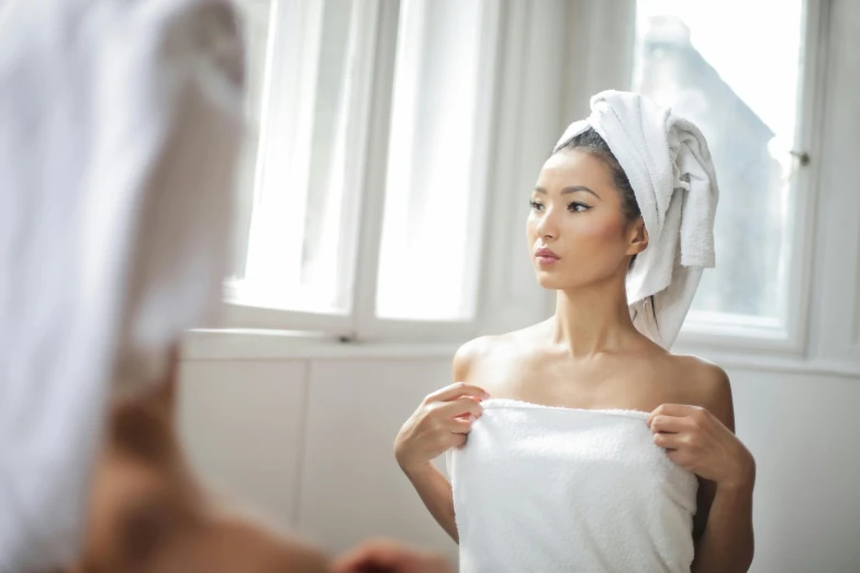 a woman standing in front of a mirror with a towel on her head, asian descent, upper body image, straight stiff dry damaged hair, thumbnail