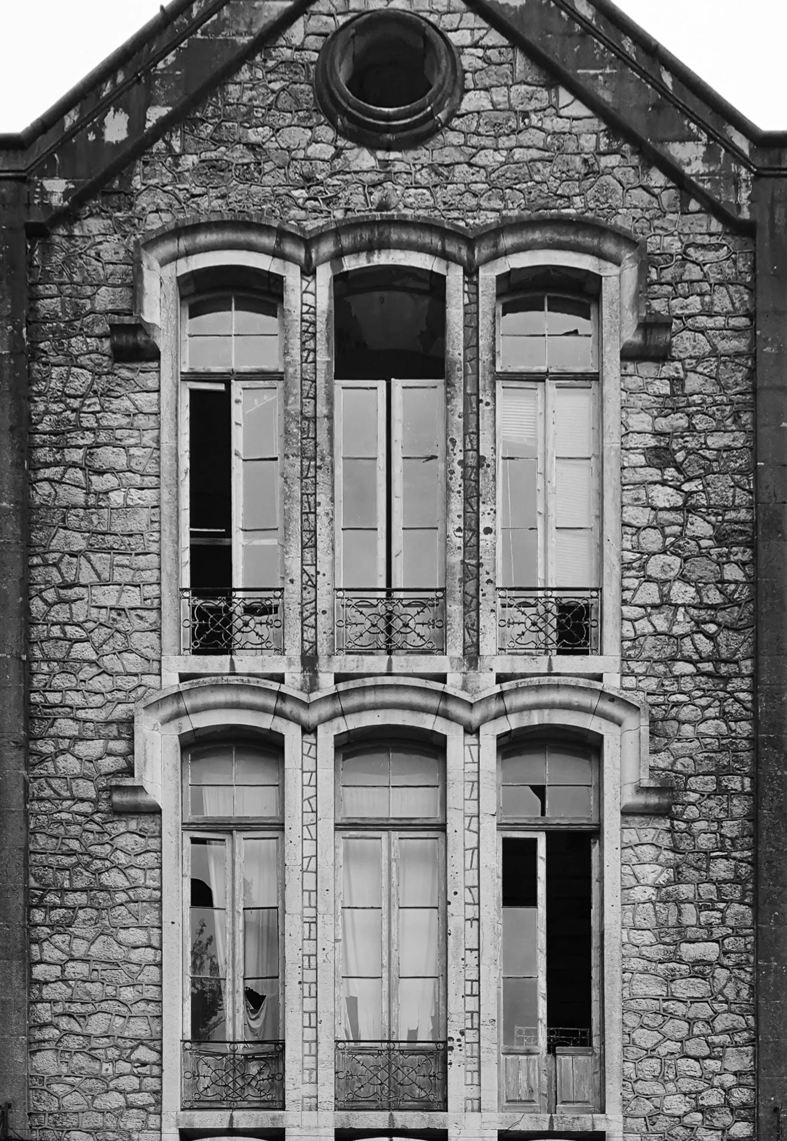 a black and white photo of an old building, inspired by André Kertész, flickr, art nouveau, made of stone and concrete, large windows to french town, ( ( photograph ) ), realistic windows