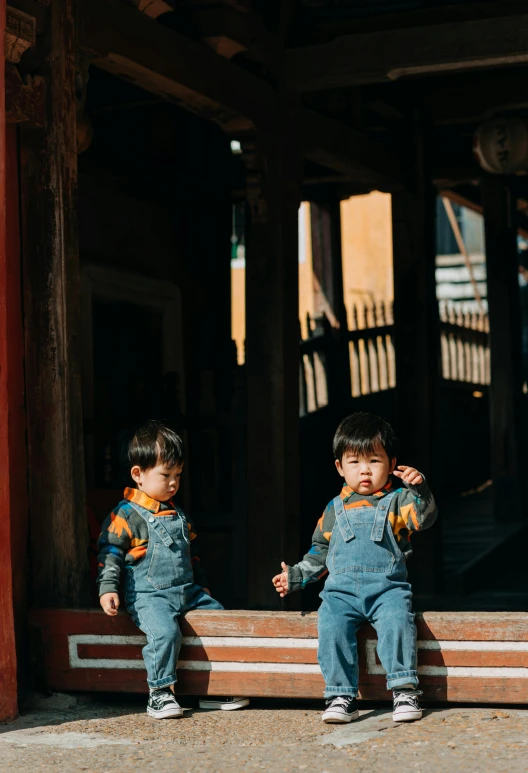 two children sitting on a bench in front of a building, pexels contest winner, qing dynasty, wearing overalls, in a temple, slide show