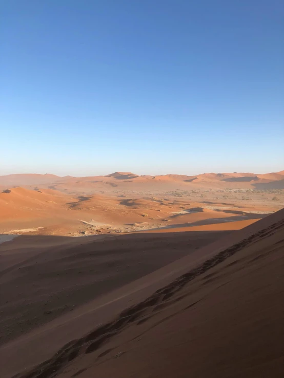 a person standing on top of a sand dune, valley in the distance, extremely complex, sandy colours, craters