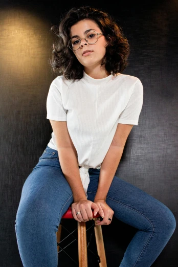 a woman sitting on top of a wooden stool, plain white tshirt, rebecca sugar, high quality image, cindy avelino