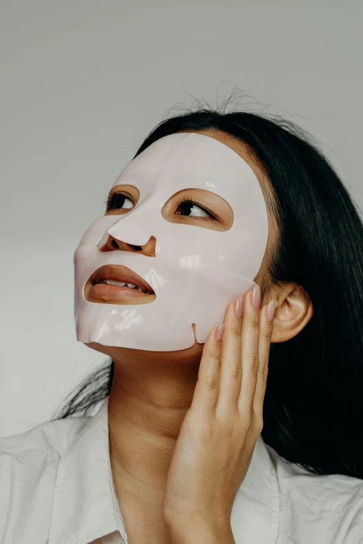 a woman with a sheet mask on her face, trending on pexels, asian human, glossy white, made of lab tissue, pink face