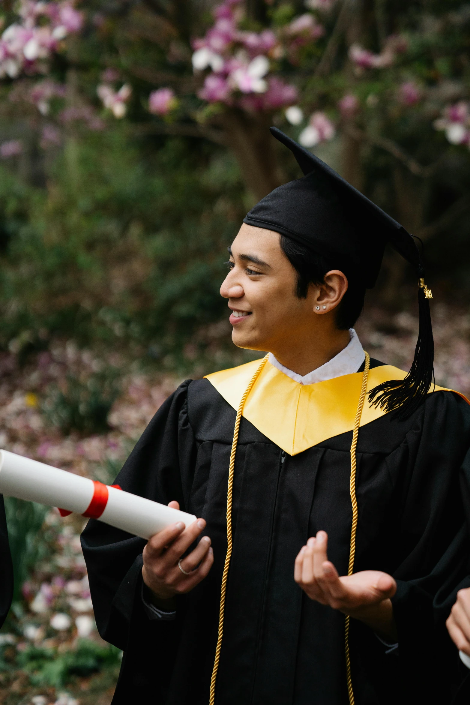 a man in a graduation cap and gown holding a diploma, pexels contest winner, medium shot of two characters, asian male, promo image, delightful surroundings