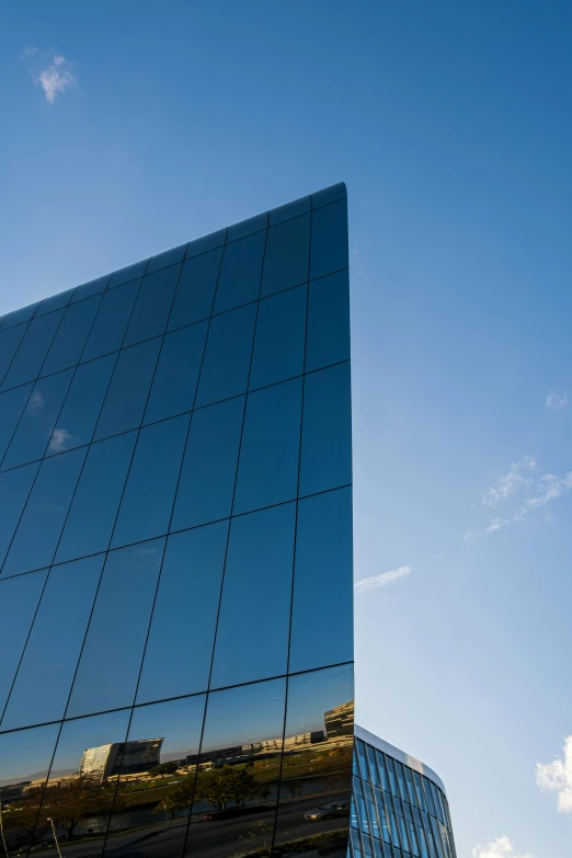 a reflection of a building on the side of a building, inspired by Richard Wilson, unsplash, minimalism, cloudless sky, high-quality photo, dynamic angled shot, square shapes