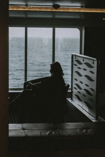 a person sitting in a chair looking out a window, on a boat, sombre mood, chillhop, on ship