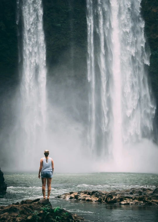 a woman standing in front of a waterfall, pexels contest winner, facing away from camera, indonesia national geographic, full frame image, 4k)