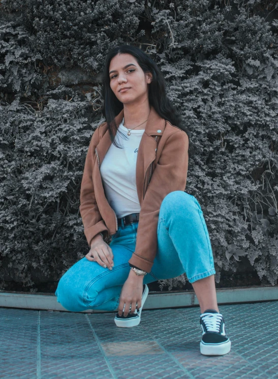 a woman sitting on the ground with a skateboard, pexels contest winner, short brown leather jacket, avatar image, ( ( ( wearing jeans ) ) ), promotional image