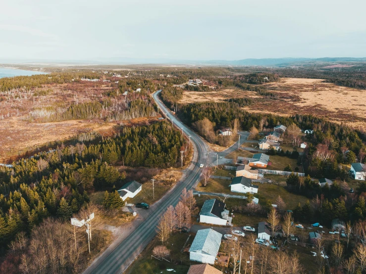 an aerial view of a small town surrounded by trees, by Jaakko Mattila, pexels contest winner, happening, ultrawide cinematic, quebec, looking partly to the left, countryside