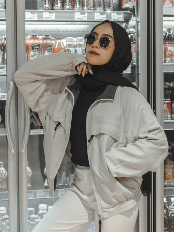 a woman standing in front of a vending machine, inspired by Shaddy Safadi, unsplash, hurufiyya, wearing off - white style, wearing an aviator jacket, with grey skin, detailed product image