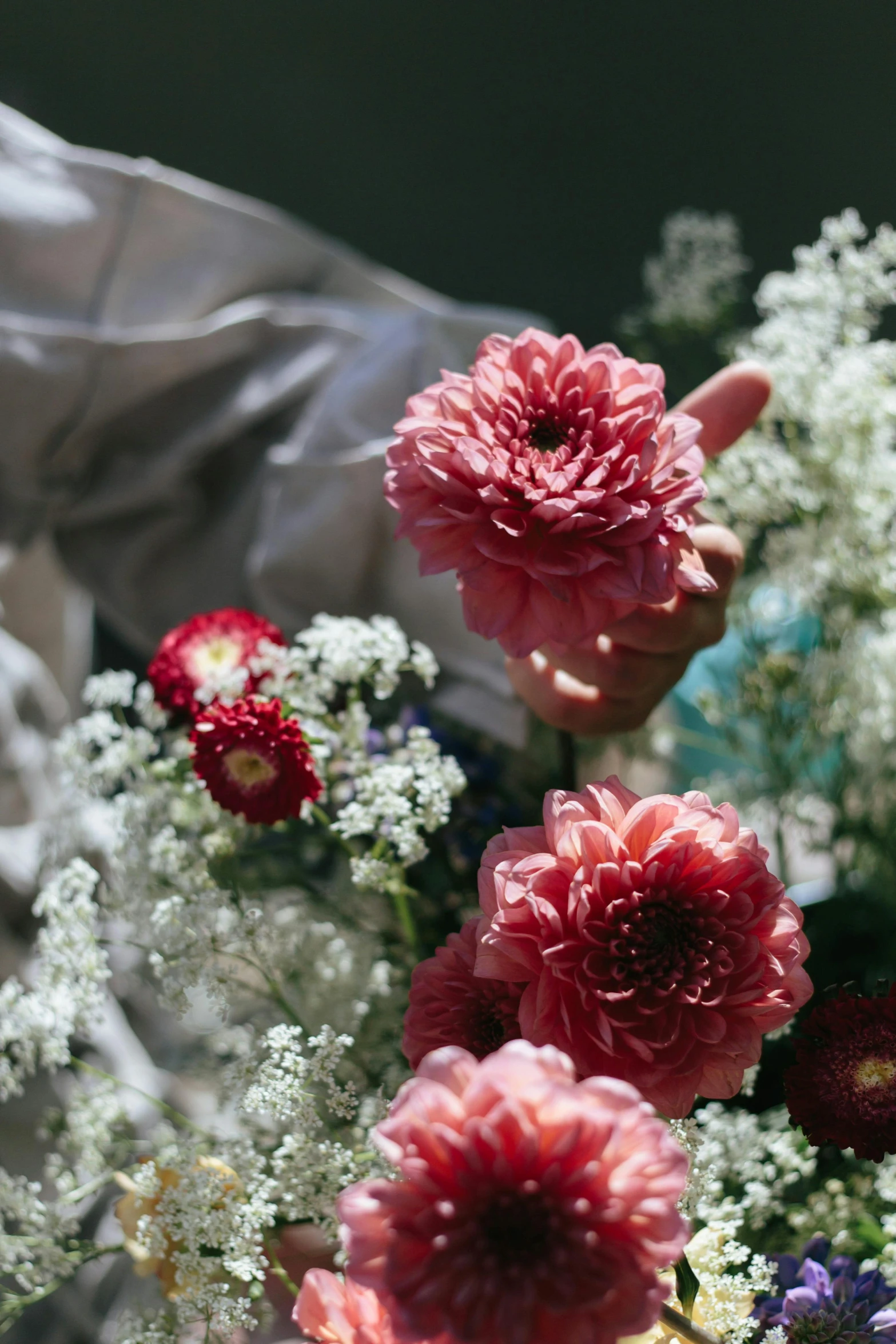 a close up of a bunch of flowers in a vase, midsommar color theme, hands, with red haze, al fresco