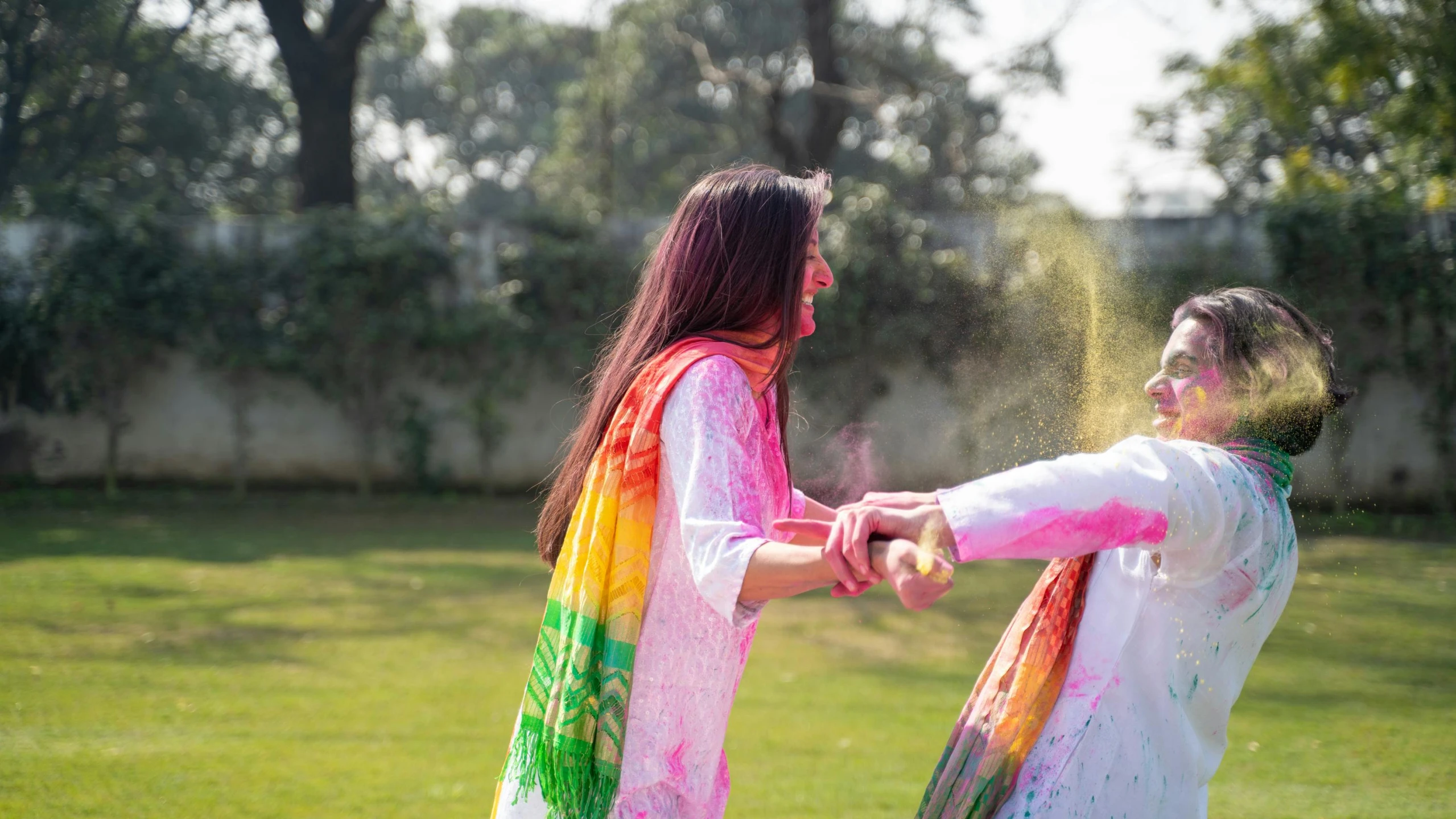 a couple of women standing on top of a lush green field, pexels contest winner, action painting, wearing a silk kurta, covered in white flour, multicoloured, game